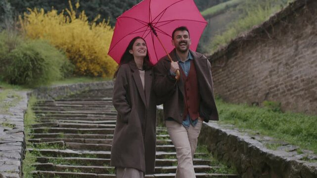 A couple sharing an umbrella on a rainy day, symbolizing mutual care and support in a healthy relationship.