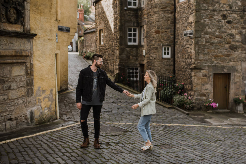 Cobblestone lane and the Water of Leith at Dean Village with a couple walking.